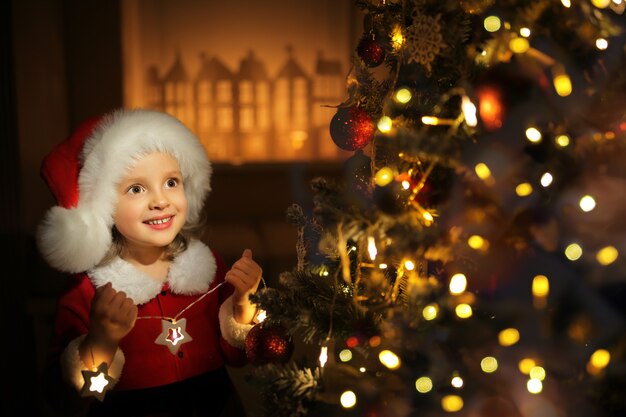 Ragazzo carino che si prepara a casa per la celebrazione di Natale in previsione delle vacanze e un regalo di Babbo Natale