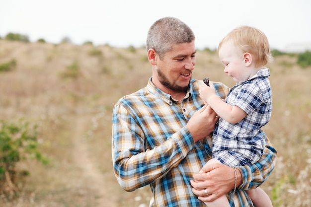 Ragazzo carino con papà gioca all'aperto