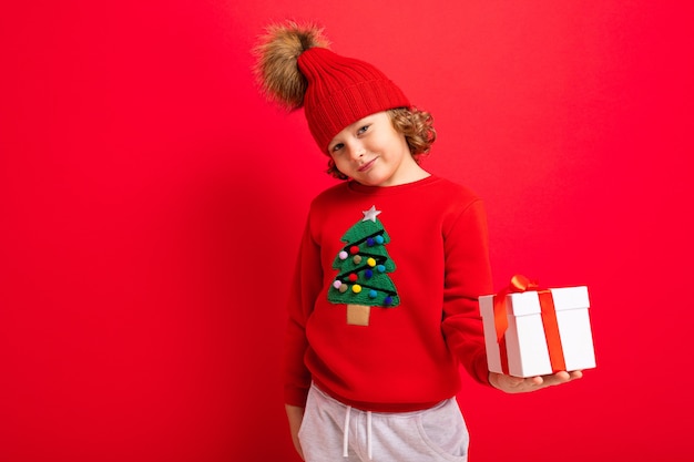 Ragazzo carino con un maglione di Natale e un cappello