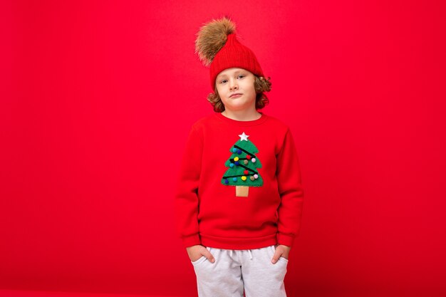 Ragazzo carino con un maglione di Natale e un cappello