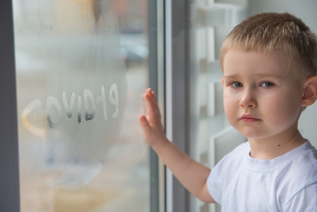 Ragazzo carino guardando attraverso la finestra