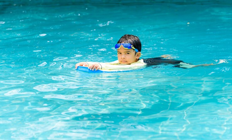 Ragazzo carino, imparando a nuotare in piscina