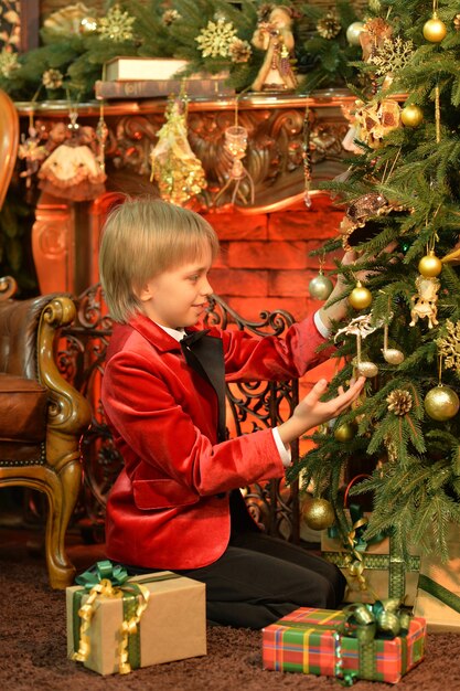 Ragazzo carino in posa vicino all'albero di Natale