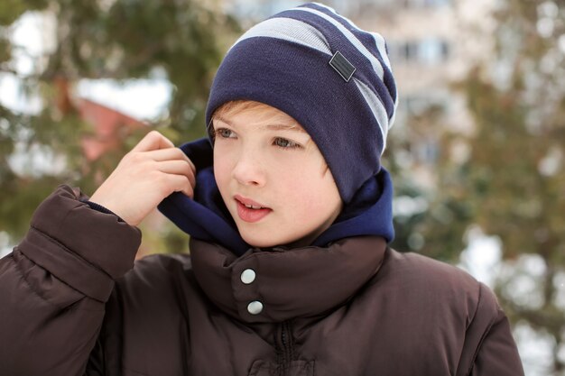 Ragazzo carino nel parco in vacanza invernale