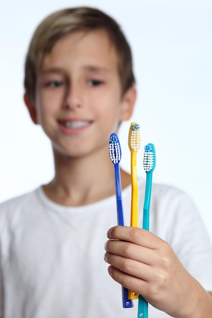 Ragazzo casuale che tiene spazzolino da denti e sorriso