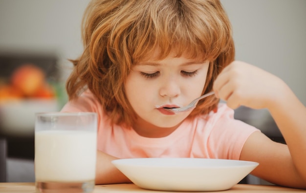 Ragazzo caucasico del bambino del bambino che mangia zuppa sana in cucina