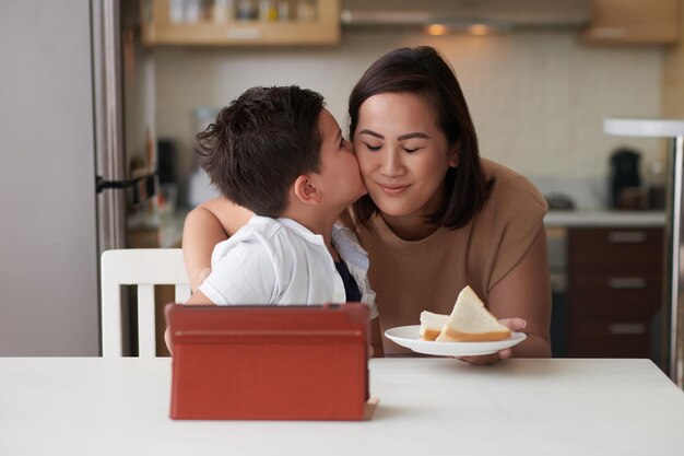 Ragazzo che bacia madre sulle guance