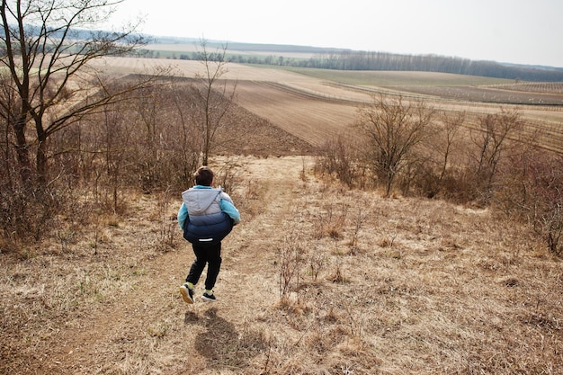 Ragazzo che corre sul campo all'inizio della primavera