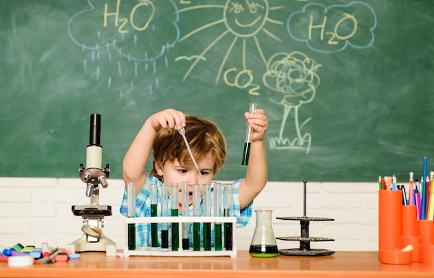 Ragazzo che esegue il test di chimica Meraviglia e sviluppo precoce Il piccolo allievo impara la scuola di chimica Laboratorio di chimica Concetto di conoscenza pratica Scopri i liquidi Borse di studio e borsa di studio