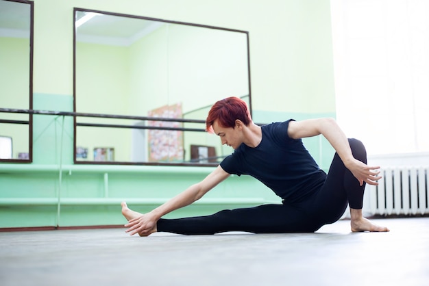 Ragazzo che fa esercizi di balletto nel salone di balletto