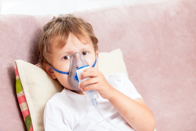 Ragazzo che fa inalazione con un nebulizzatore a casa