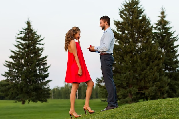 Ragazzo che fa la proposta di una ragazza nel mezzo di un bellissimo parco, un ragazzo dà un anello per la ragazza, la ragazza...