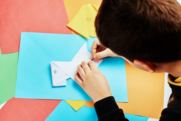 Ragazzo che fa origami di cane di carta