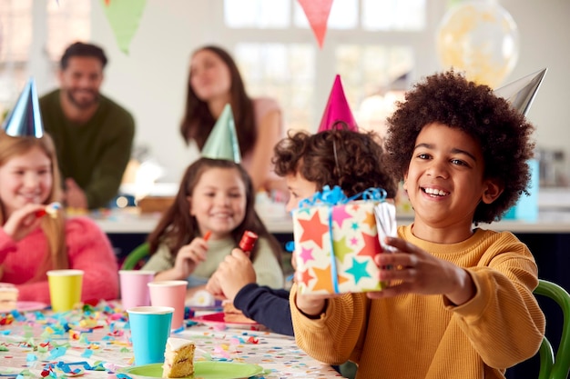 Ragazzo che fa un regalo alla festa di compleanno con amici e genitori a casa