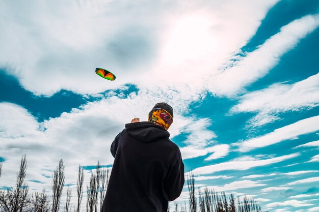 Ragazzo che fa volare un grande aquilone in una giornata ventosa