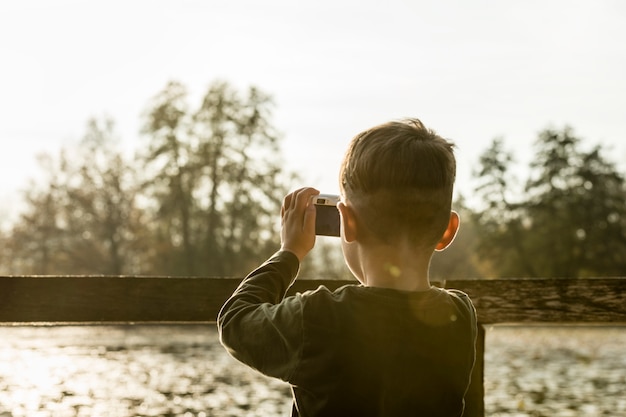 Ragazzo che fotografa natura con una macchina fotografica compatta