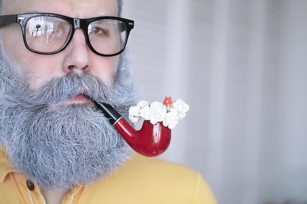 Ragazzo che fuma tabacco da pipa Hipster con barba grigia e baffi Cattive abitudini conce