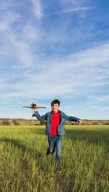 Ragazzo che funziona con un aereo in un parco.