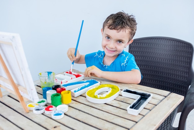 Ragazzo che gioca con i colori usando le mani e il viso