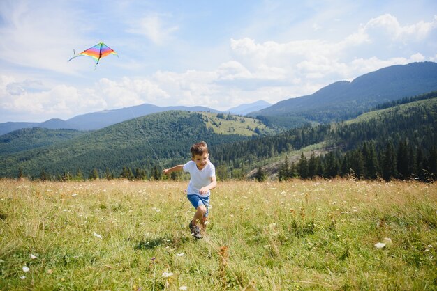 Ragazzo che gioca con un aquilone in montagna