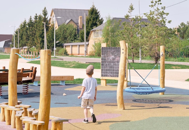 Ragazzo che gioca nel parco giochi vuoto