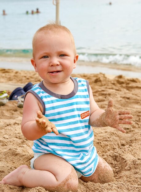 Ragazzo che gioca nella sabbia e nelle onde sulla spiaggia