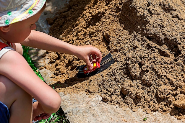 Ragazzo che gioca nella sandbox sul parco giochi