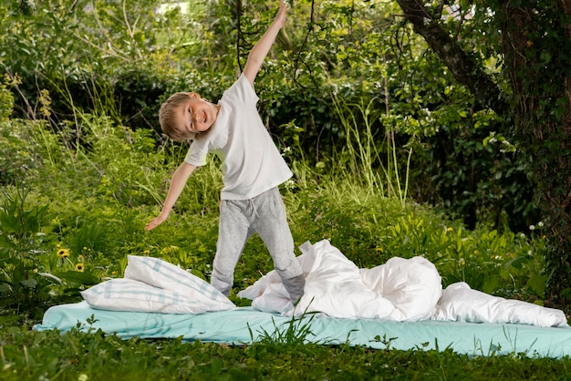 Ragazzo che gioca sul letto in giardino