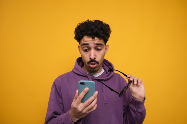 Ragazzo che guarda il suo telefono senza occhiali da sole