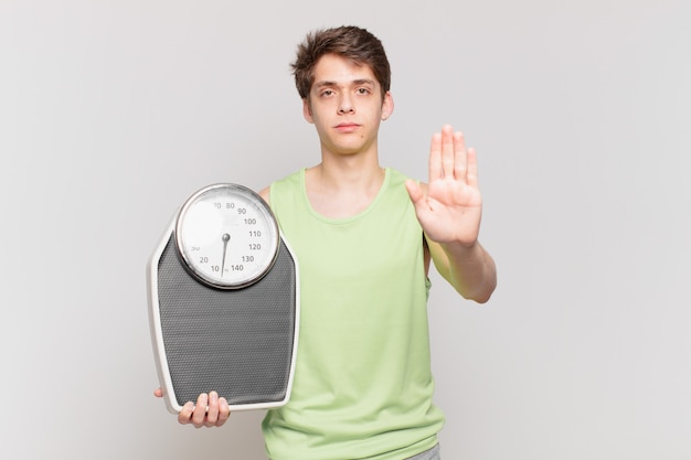 Ragazzo che indossa abiti da fitness con un concetto di bilancia