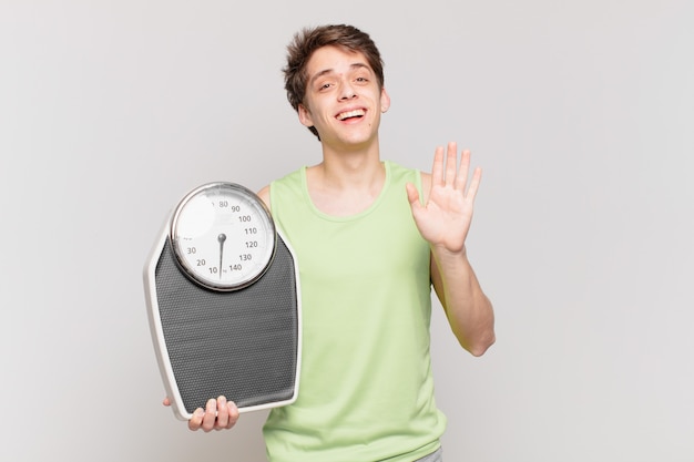 Ragazzo che indossa abiti da fitness con un concetto di bilancia