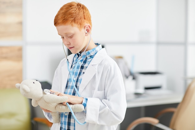 Ragazzo che indossa camice bianco e che gioca medico