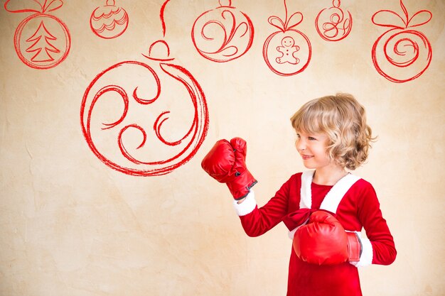 Ragazzo che indossa guanti da boxe rossi. Concetto di vacanza di Natale