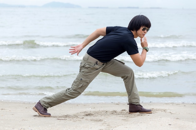 Ragazzo che indossa pantaloni cargo e in piedi sulla spiaggia