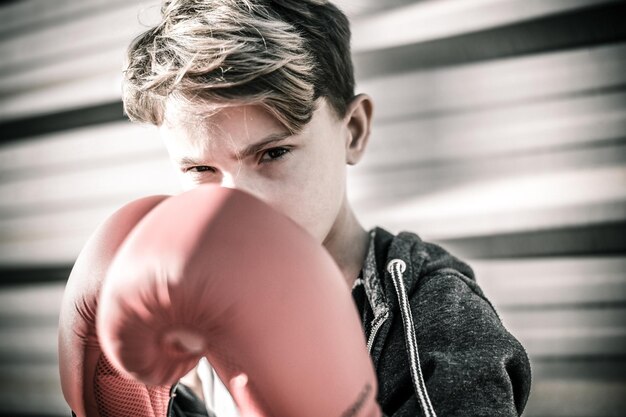 Ragazzo che indossa un guanto da boxe mentre è all'aperto