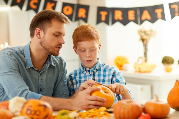 Ragazzo che intaglia zucca con il padre