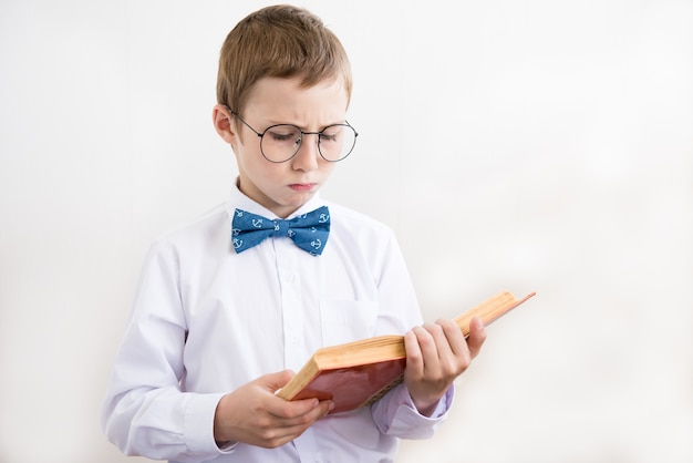 Ragazzo che legge un libro in grandi bicchieri