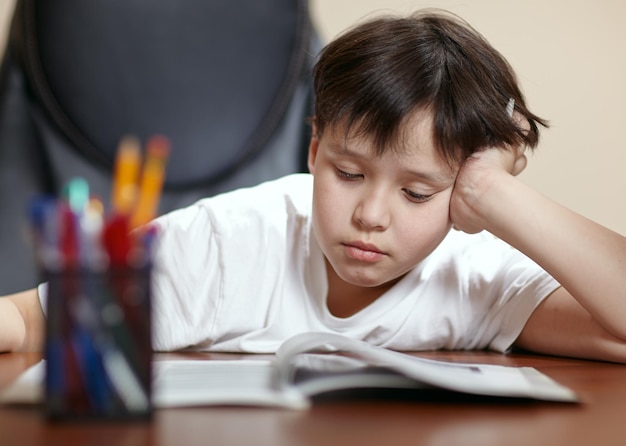 Ragazzo che legge un libro sul tavolo