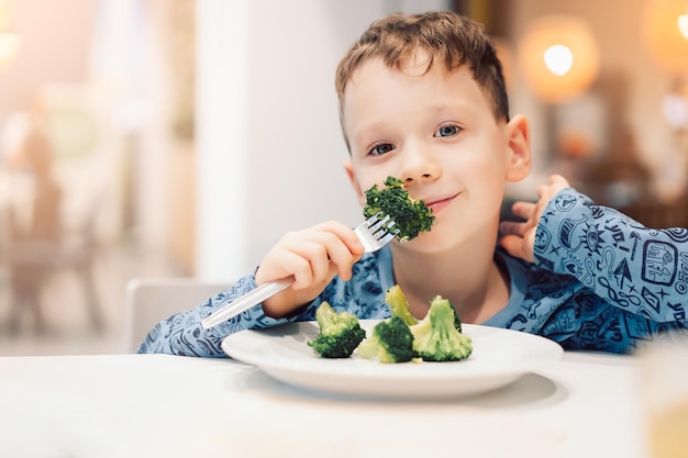 ragazzo che mangia broccoli cibo sano