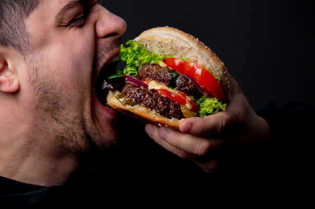 Ragazzo che mangia hamburger americano classico