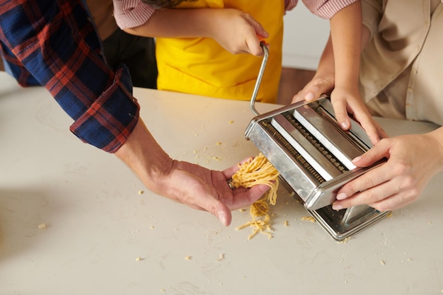 Ragazzo che mette la pasta nella macchina