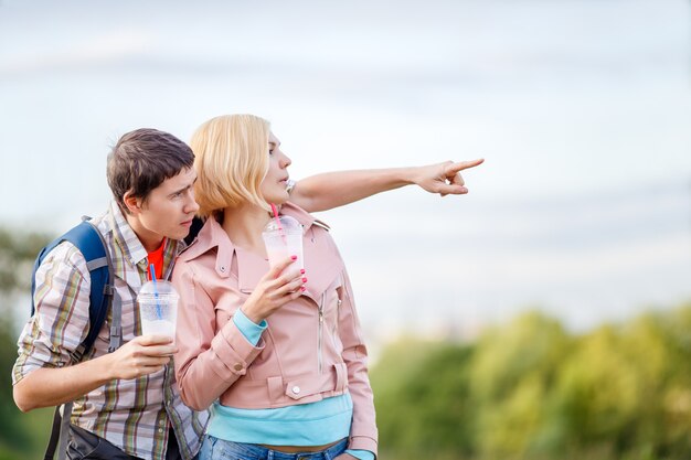 Ragazzo che mostra la mano alla distanza nel parco con la ragazza