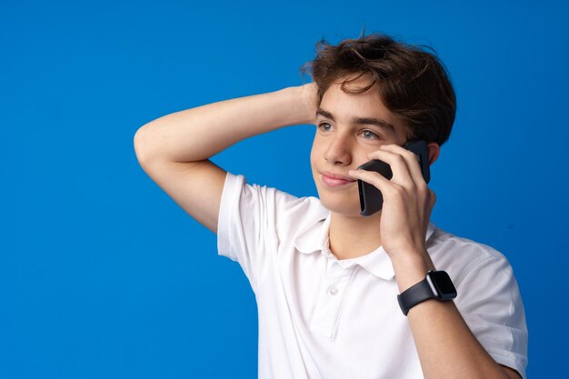 Ragazzo che parla dal telefono cellulare su sfondo blu