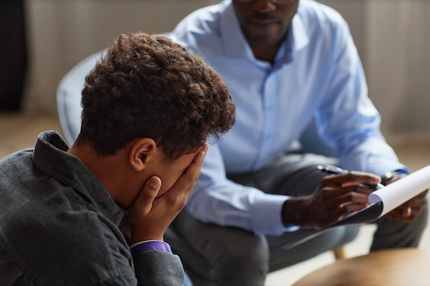 Ragazzo che piange in visita a uno psicologo della scuola