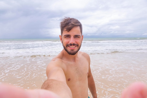 Ragazzo che prende un selfie sulla spiaggia