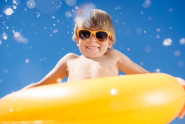 Ragazzo che salta in piscina nel parco acquatico