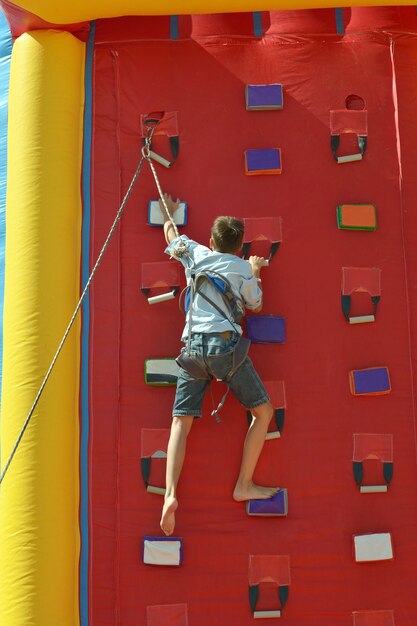 Ragazzo che scala un muro per raggiungere la cima