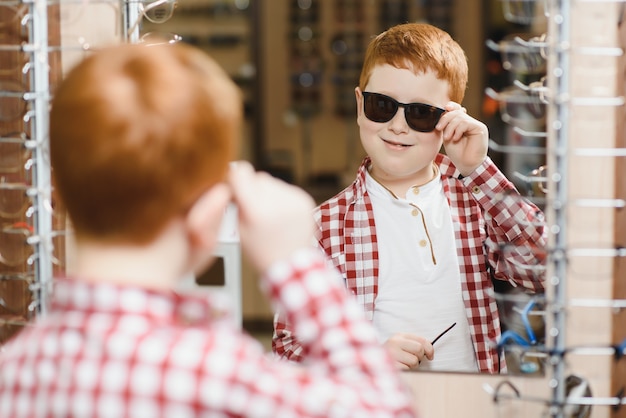 Ragazzo che sceglie gli occhiali al negozio di ottica.