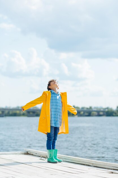 Ragazzo che si sente felice mentre vede il sole dopo la pioggia