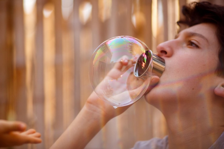 Foto ragazzo che soffia bolle mentre è in piedi all'aperto